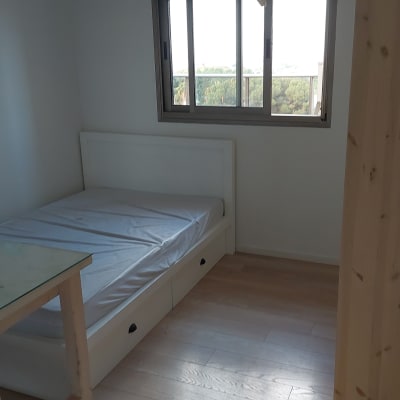 חדר שינה עם מיטה, שולחן וחלון