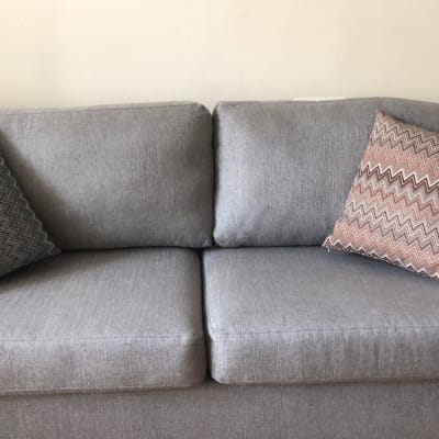 ספה אפורה עם כריות דקורטיביות בזיגזג