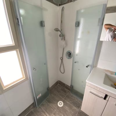 מקלחת עם דלתות זכוכית וברז גשם