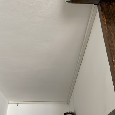 תעלת כבלים על תקרה לבנה ליד קורה מעץ