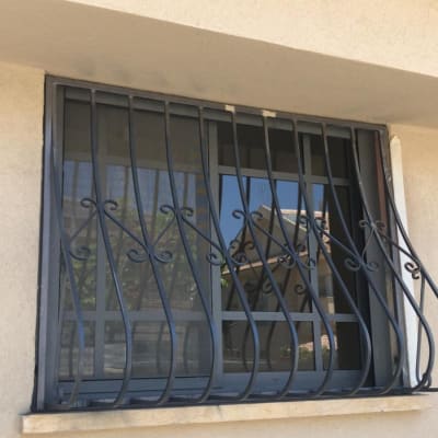 סורגי ברזל מעוצבים על חלון זכוכית