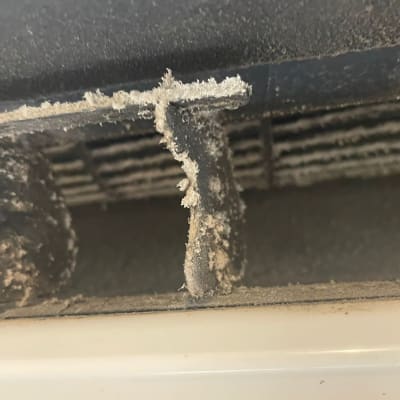 תקריב של פתח מזגן עם אבק ולכלוך