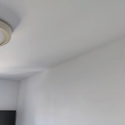 קיר ותקרה צבועים בלבן עם מנורה עגולה