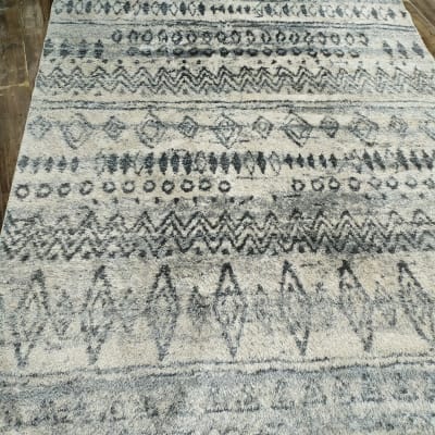 שטיח עם דוגמאות גיאומטריות על רצפת עץ