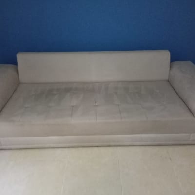 ספה אפורה על רקע קיר כחול