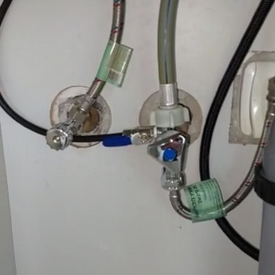 צינורות מים מתכתיים עם ברזים מתחת לכיור