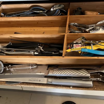 מגירת מטבח עם כלי מטבח שונים ומסננת מתכת