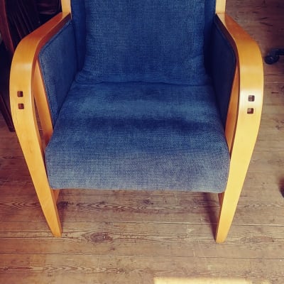 כורסה עם ריפוד כחול ומסגרת עץ בהירה