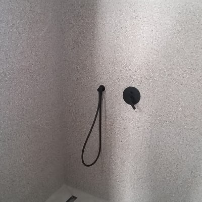 מקלחת עם ראש מקלחת שחור וקיר אריחים
