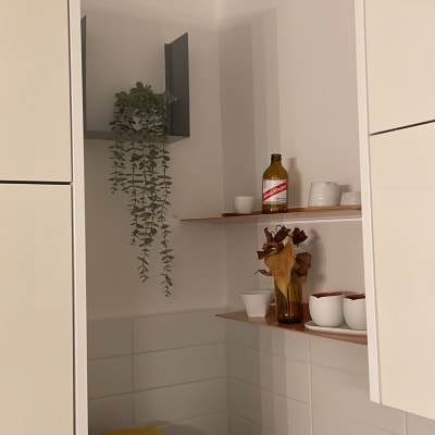 מדף עם בקבוק וכלים במטבח, מכונת קפה על השיש