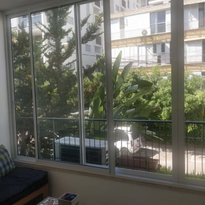 חלונות אלומיניום גדולים עם נוף לעצים ובניינים