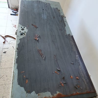 דלת מתכת עם צבע מתקלף, כלים על הרצפה