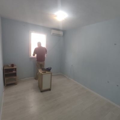 אדם עומד ליד חלון בחדר צבוע בצבע תכלת