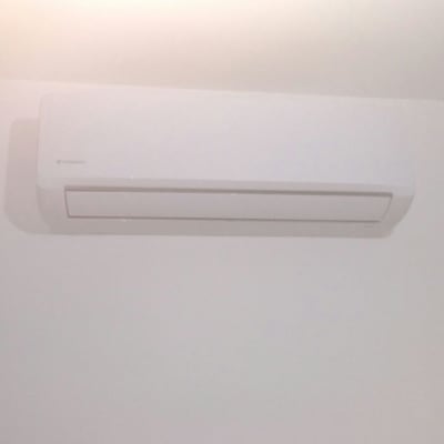 מזגן קיר לבן מותקן על קיר לבן