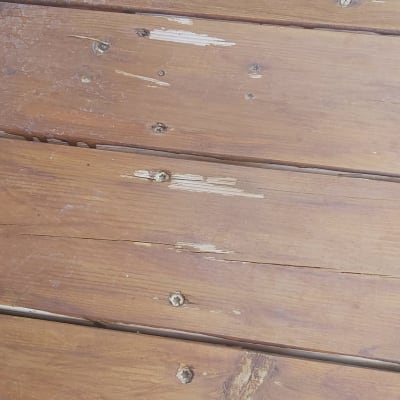 לוחות עץ עם סימני שחיקה וברגים חשופים