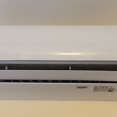 מזגן קיר לבן עם תצוגת טמפרטורה דיגיטלית