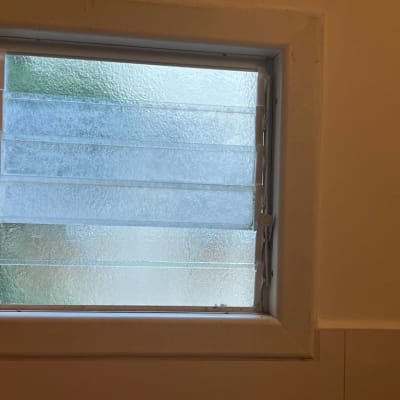 חלון עם זכוכית מחוספסת ומסגרת לבנה