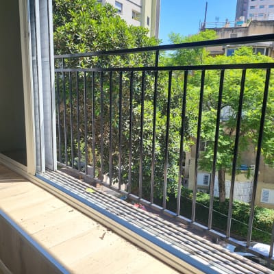 מעקה מתכת שחור במרפסת עם חלון פתוח