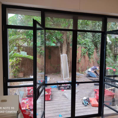 חלונות אלומיניום פתוחים עם כלי עבודה על הרצפה