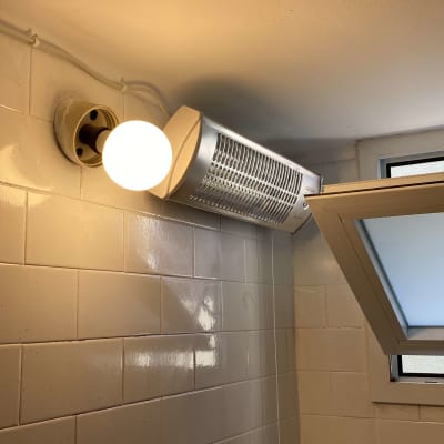 מנורת קיר ותנור חימום בחדר אמבטיה