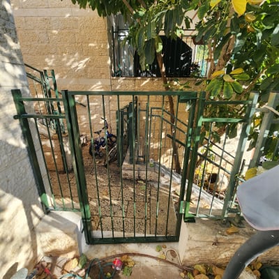 שער מתכת ירוק עם עלים מסביב