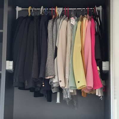 מעילים תלויים על קולבים בארון מסודר