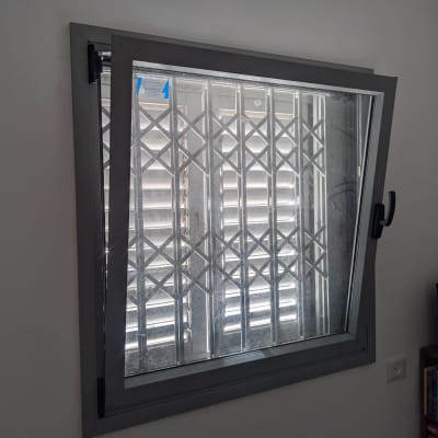 תריסים סגורים מאחורי חלון עם סורגים