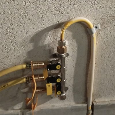 צינורות גז מחוברים לשסתום על קיר בטון