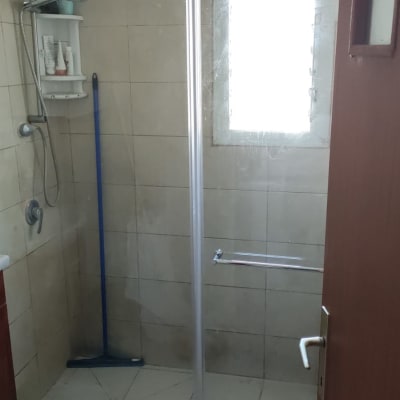 מקלחת עם מדף מוצרים ודלת זכוכית