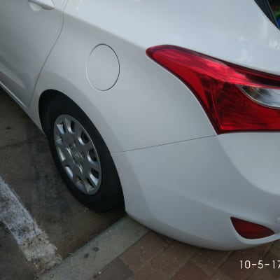 חלק אחורי של רכב לבן עם פנס אדום