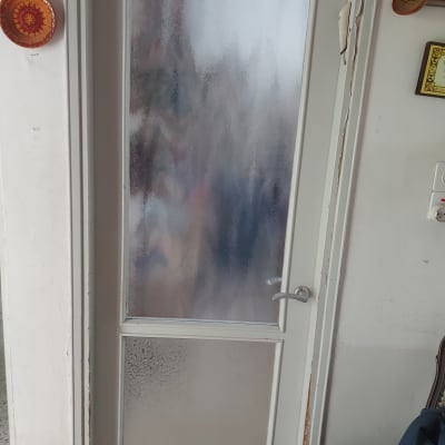 דלת עם זכוכית חלבית במרכז ובחלק התחתון