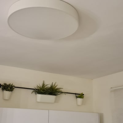 תקרה צבועה בלבן עם מנורה עגולה