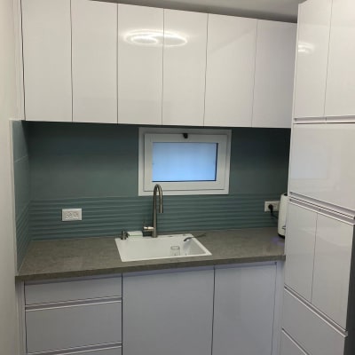 מטבח מודרני עם ארונות לבנים וכיור נירוסטה