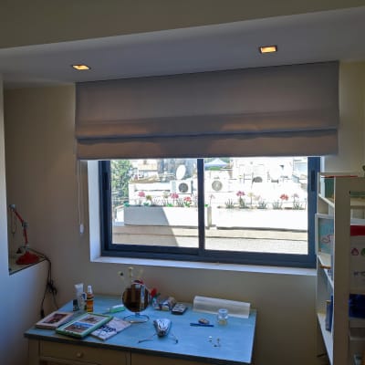 וילון רומי אפור תלוי על חלון גדול