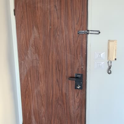 דלת עץ עם ציפוי דמוי עץ, ידית ומנעול שחורים