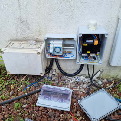 ארון חשמל פתוח עם חוטים וכלים על הקרקע