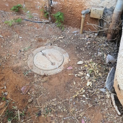 צינורות מים ופתח ביוב בחצר