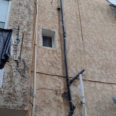 צינורות פלסטיק חיצוניים על קיר בניין