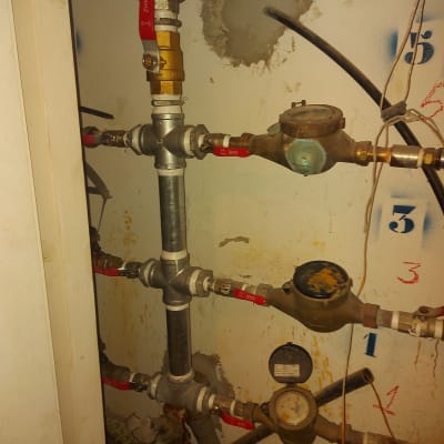 צינורות מים עם ברזים ומדי מים על קיר