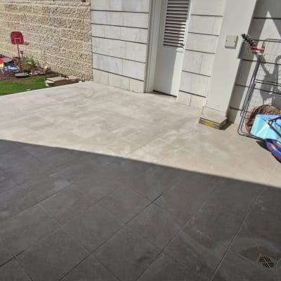 מרפסת מרוצפת עם צינור מים ואריחים חדשים