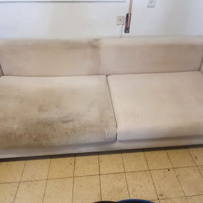 ספה מלוכלכת עם כתמים כהים על הריפוד