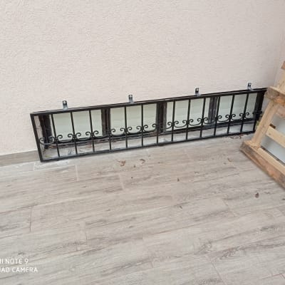 מסגרת מתכת שחורה עם עיטורים על רצפה אפורה