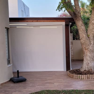 סוכך לבן מתוח על מסגרת עץ בחצר