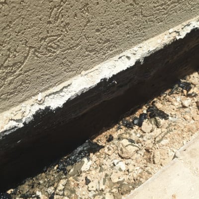 איטום קיר חיצוני עם חומר שחור על בסיס בטון