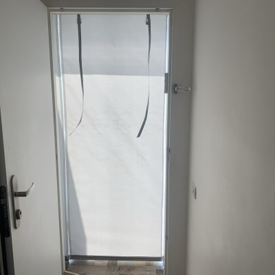 וילון לבן תלוי על דלת זכוכית
