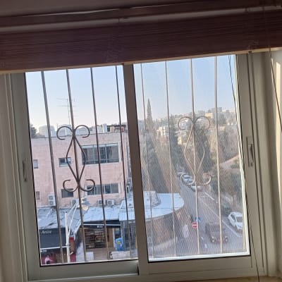 חלון אלומיניום עם סורגים דקורטיביים