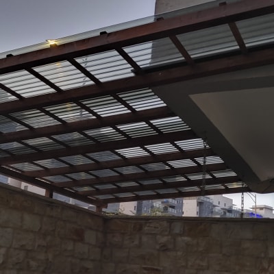 פרגולה מעץ עם גג פלסטיק שקוף בחצר