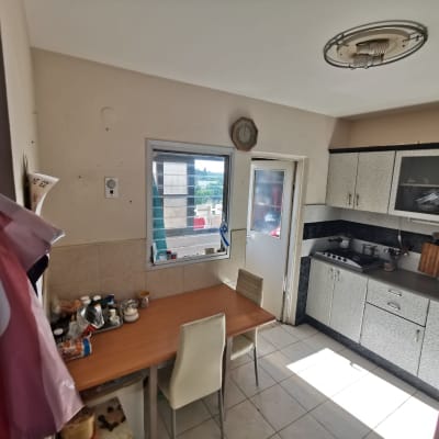 מטבח עם ארונות, שולחן עץ, ותאורה ללא כיסוי