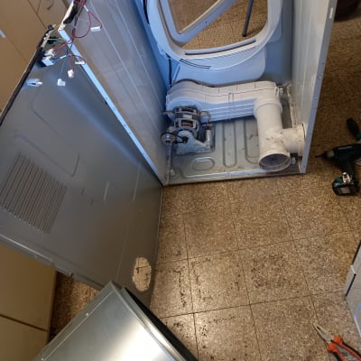 מכונת כביסה פתוחה עם חוטי חשמל וכלים