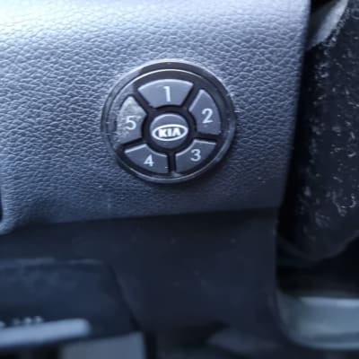 כפתור שליטה עם מספרים ולוגו קיה ברכב